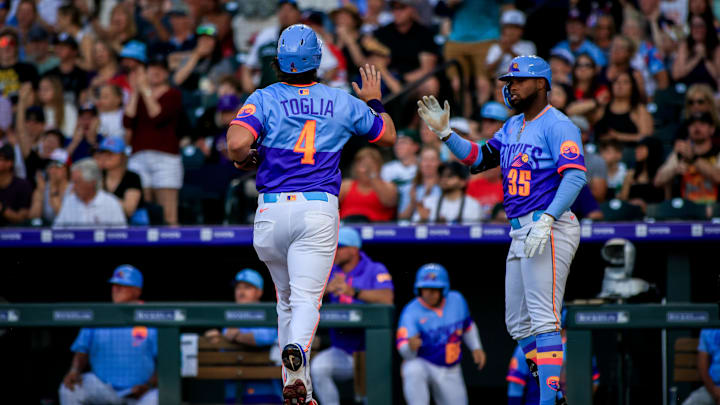 Jul 4, 2025; Denver, Colorado, USA; Colorado Rockies first base Michael Toglia (4) is congratulated by Colorado Rockies outfielder Yanquiel Fernández (35) while scoring a run against the Chicago White Sox at Coors Field. Mandatory Credit: Chet Strange-Imagn Images
