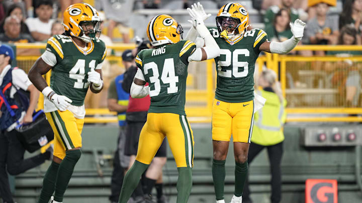Aug 9, 2025; Green Bay, Wisconsin, USA;  Green Bay Packers cornerback Kalen King (34) and cornerback Micah Robinson (26) celebrate blocking a pass during the second half against the New York Jets at Lambeau Field. Mandatory Credit: Kayla Wolf-Imagn Images