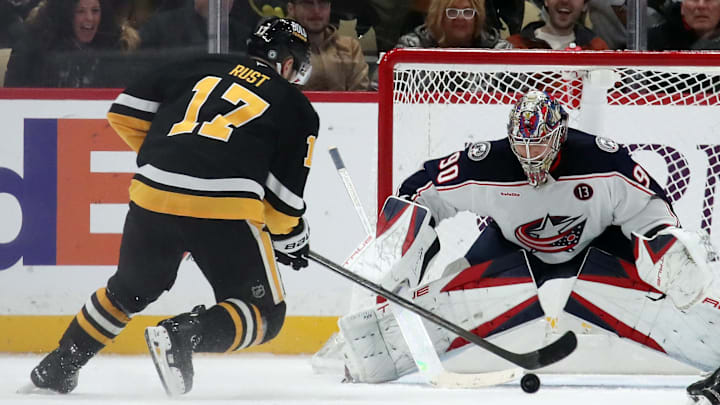 Jan 7, 2025; Pittsburgh, Pennsylvania, USA; Columbus Blue Jackets goaltender Elvis Merzlikins (90) defends the net against Pittsburgh Penguins right wing Bryan Rust (17) in overtime at PPG Paints Arena. Mandatory Credit: Charles LeClaire-Imagn Images