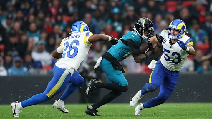 [US, Mexico & Canada customers only] Oct 19, 2025; London, United Kingdom; Jacksonville Jaguars wide receiver Travis Hunter (12) runs with the ball against Los Angeles Rams safety Kamren Kinchens (26) and linebacker Nate Landman (53) during the second half during a NFL International Series game at Wembley Stadium. Mandatory Credit: Andrew Boyers-Reuters via Imagn Images
