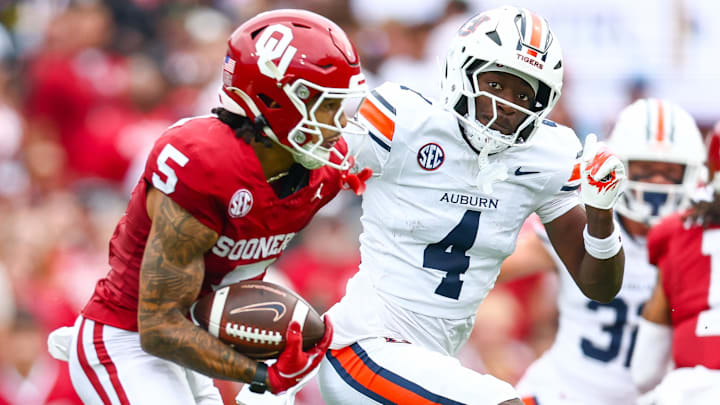 Sep 20, 2025; Norman, Oklahoma, USA; Oklahoma Sooners wide receiver Isaiah Sategna III (5) runs with the ball as Auburn Tigers cornerback Kayin Lee (4) defends during the first half at Gaylord Family-Oklahoma Memorial Stadium. Mandatory Credit: Kevin Jairaj-Imagn Images