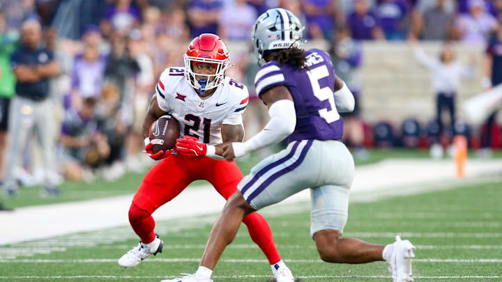 Sep 13, 2024; Manhattan, Kansas, USA; Arizona Wildcats running back Rayshon Luke (21) looks for room to run against Kansas State Wildcats cornerback Justice James (5) during the first quarter at Bill Snyder Family Football Stadium