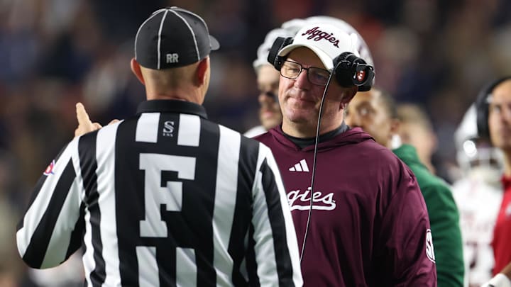 Nov 23, 2024; Auburn, Alabama, USA;  Texas A&M Aggies head coach Mike Elko speaks with a game official during the second quarter against the Auburn Tigers at Jordan-Hare Stadium. Mandatory Credit: John Reed-Imagn Images