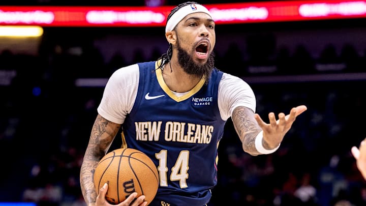 Dec 5, 2024; New Orleans, Louisiana, USA;  New Orleans Pelicans forward Brandon Ingram (14) reacts to a play against Phoenix Suns guard Devin Booker (1) during the first half  at Smoothie King Center. Mandatory Credit: Stephen Lew-Imagn Images