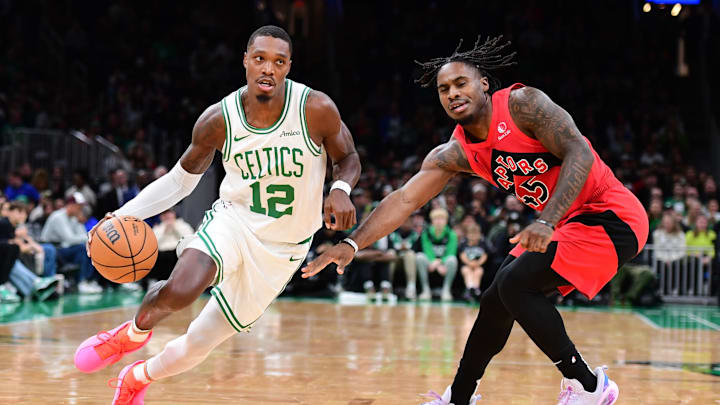 Oct 13, 2024; Boston, Massachusetts, USA; Boston Celtics guard Lonnie Walker IV (12) controls the ball while Toronto Raptors guard Davion Mitchell (45) defends during the first half at TD Garden. Mandatory Credit: Bob DeChiara-Imagn Images