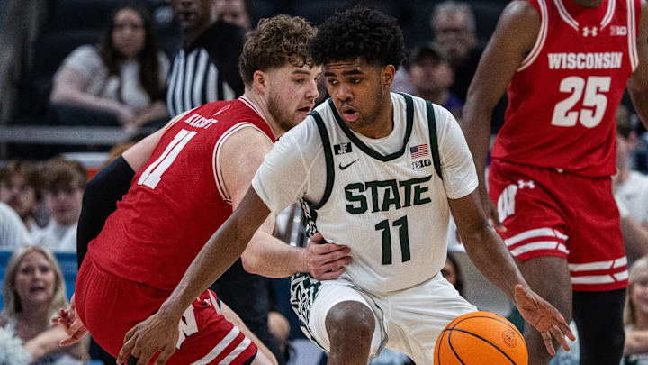 Mar 15, 2025; Indianapolis, IN, USA; Michigan State Spartans guard Jase Richardson (11) dribbles  the ball while Wisconsin Badgers guard Max Klesmit (11) defends in the second half  at Gainbridge Fieldhouse. Mandatory Credit: Trevor Ruszkowski-Imagn Images