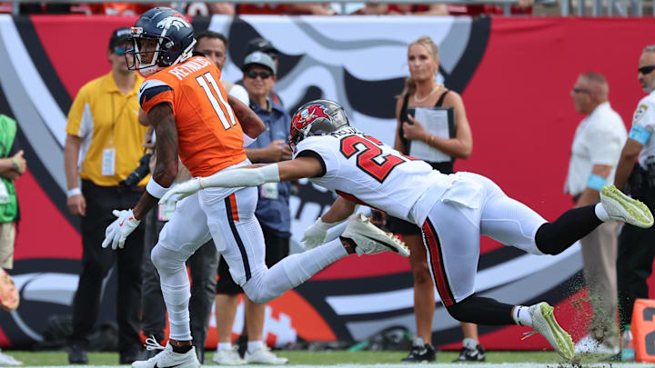 Sep 22, 2024; Tampa, Florida, USA; Denver Broncos wide receiver Josh Reynolds (11) runs with the ball as Tampa Bay Buccaneers cornerback Zyon McCollum (27) defends during the first quarter at Raymond James Stadium. 