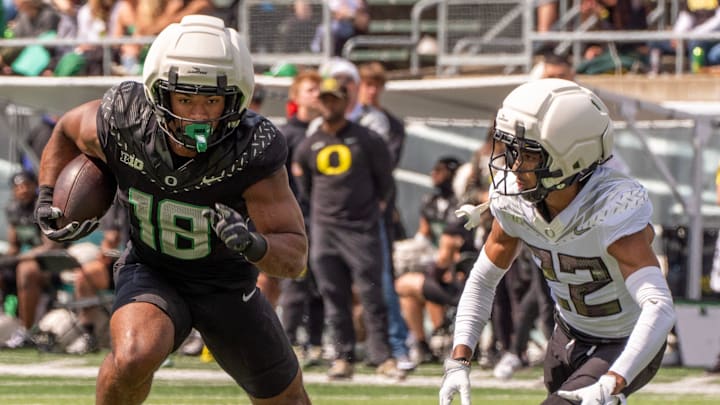 Combat Duck Kenyon Sadiq, left, runs ahead of Fighting Duck defender Jadon Canady during the second half of the Oregon Spring game.