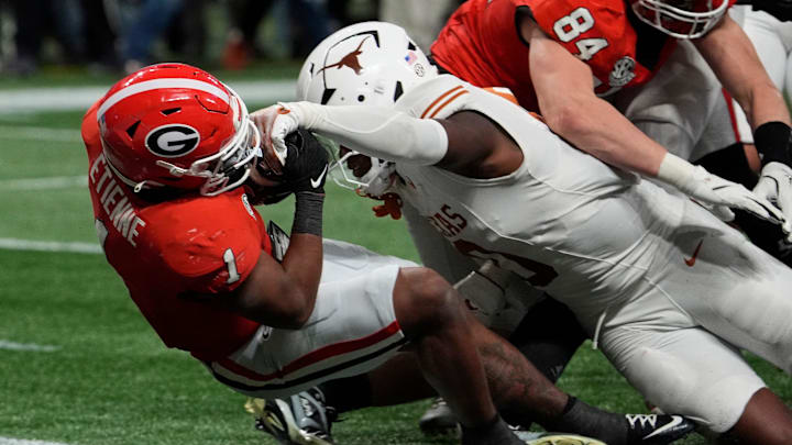 Georgia running back Trevor Etienne (1) powers past Texas linebacker Anthony Hill Jr. (0) to score the game winning touchdown during overtime of the SEC championship game against Texas in Atlanta, on Saturday, Dec. 7, 2024.
