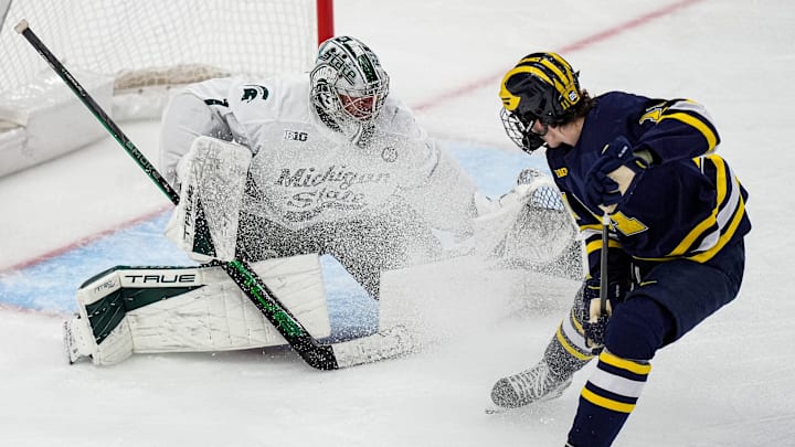 Michigan State goaltender Trey Augustine (1) makes a save against Michigan forward Cole McKinney (11) during the second period of Duel in the D at Little Caesars Arena in Detroit on Saturday, February 7, 2026.