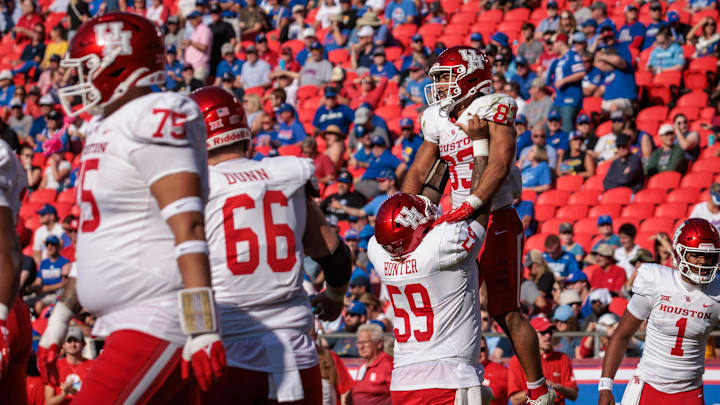 Houston Cougars wide receiver Mekhi Mews (83) is lifted up by offensive lineman Demetrius Hunter (59) after scoring a touchdown against the Kansas Jayhawks during the second quarter at GEHA Field at Arrowhead Stadium. Mandatory Credit: William Purnell-Imagn Images