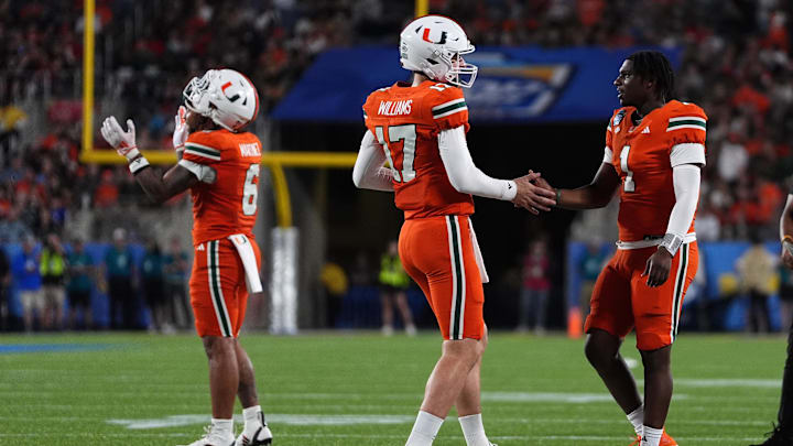 Dec 28, 2024; Orlando, FL, USA; Miami Hurricanes quarterback Emory Williams (17) shakes hands with quarterback Cam Ward (1) after a touchdown against the Iowa State Cyclones during the second half at Camping World Stadium. Mandatory Credit: Jasen Vinlove-Imagn Images