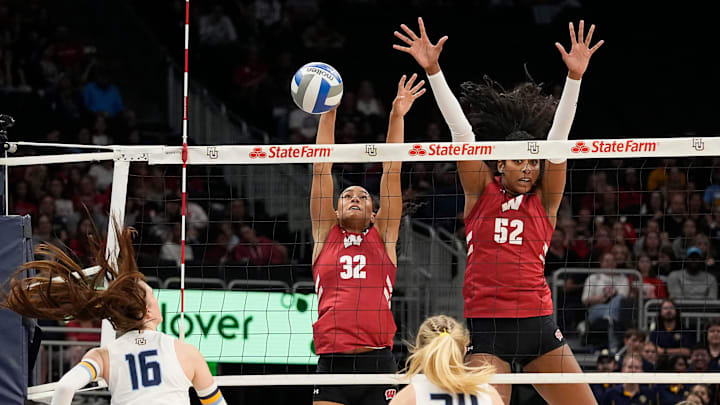 Wisconsin Badgers outside hitter Grace Egan (32) and middle blocker Carter Booth (52) block the hit from Marquette Golden Eagles outside hitter Ella Holmstrom (16) during the first set of the match on Wednesday September 17, 2025 at Fiserv Forum in Milwaukee, Wisconsin.