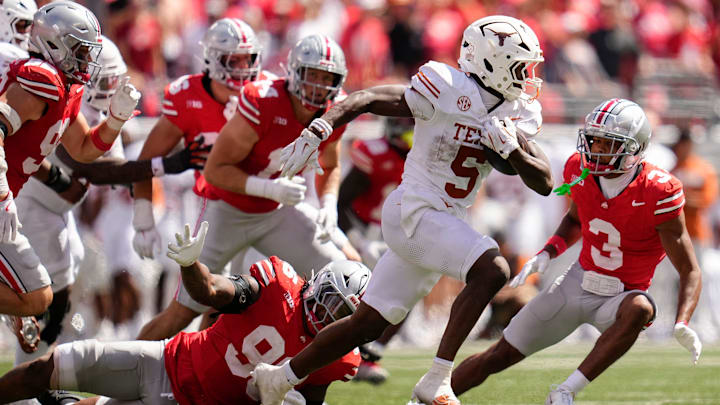 Texas Longhorns running back Quintrevion Wisner (5) runs past Ohio State Buckeyes defensive end Eddrick Houston (96) during the second half of the NCAA football game at Ohio Stadium on Aug. 30, 2025. Ohio State won 14-7.