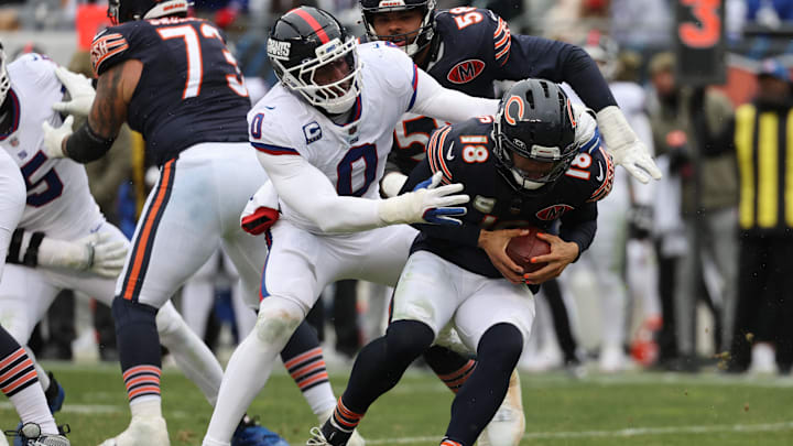 Nov 9, 2025; Chicago, Illinois, USA; Chicago Bears quarterback Caleb Williams (18) avoids the sack by New York Giants linebacker Brian Burns (0) during the second half at Soldier Field. Mandatory Credit: Mike Dinovo-Imagn Images