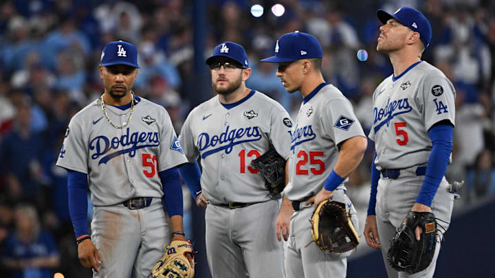 Oct 24, 2025; Toronto, Ontario, CAN; Los Angeles Dodgers shortstop Mookie Betts (50), third baseman Max Muncy (13), second baseman Tommy Edman (25) and first baseman Freddie Freeman (5) look on during a pitching change against the Toronto Blue Jays in the sixth inning during game one of the 2025 MLB World Series at Rogers Centre. Mandatory Credit: Dan Hamilton-Imagn Images