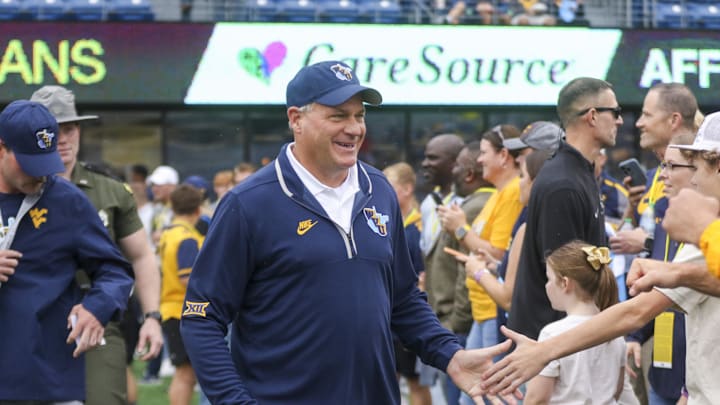 Sep 27, 2025; Morgantown, West Virginia, USA; West Virginia Mountaineers head coach Rich Rodriguez walks on the field and greets fans before their game against the Utah Utes at Milan Puskar Stadium. Mandatory Credit: Ben Queen-Imagn Images