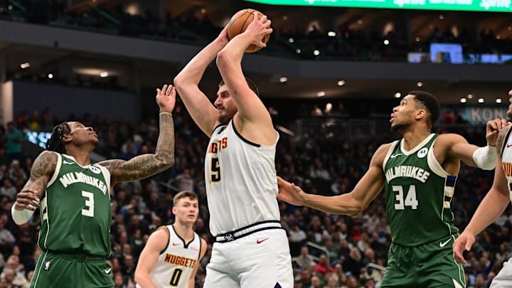 Feb 27, 2025; Milwaukee, Wisconsin, USA; Denver Nuggets center Nikola Jokic (15) grabs a rebound against Milwaukee Bucks guard Kevin Porter (3) and forward Giannis Antetokounmpo (34) in the second quarter at Fiserv Forum. Mandatory Credit: Benny Sieu-Imagn Images Feb 27, 2025; Milwaukee, Wisconsin, USA; Denver Nuggets center Nikola Jokic (15) grabs a rebound against Milwaukee Bucks guard Kevin Porter (3) and forward Giannis Antetokounmpo (34) in the second quarter at Fiserv Forum. Mandatory Credit: Benny Sieu-Imagn Images