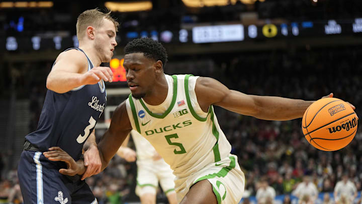 Mar 21, 2025; Seattle, WA, USA; Oregon Ducks guard TJ Bamba (5) dribbles the ball against Liberty Flames guard Kaden Metheny (3) during the first half in the first round of the NCAA Tournament at Climate Pledge Arena. Mandatory Credit: Stephen Brashear-Imagn Images Mar 21, 2025; Seattle, WA, USA; Oregon Ducks guard TJ Bamba (5) dribbles the ball against Liberty Flames guard Kaden Metheny (3) during the first half in the first round of the NCAA Tournament at Climate Pledge Arena. Mandatory Credit: Stephen Brashear-Imagn Images