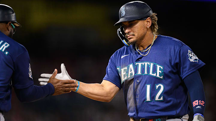 Josh Naylor (12) greets first base coach Eric Young Jr. (53) after hitting an RBI single.