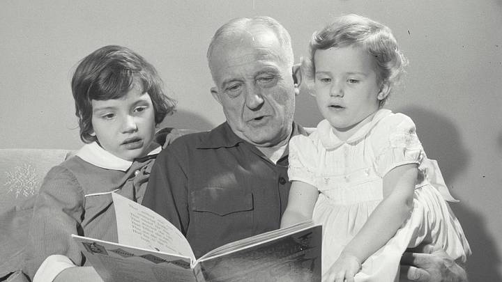 Grandfather reading story for his two grandchildren