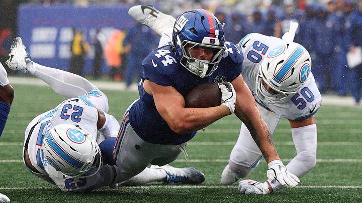 Tennessee Titans safety Kevin Winston Jr. (23) and linebacker Cody Barton (50) tackle New York Giants running back Cam Skattebo (44) during the third quarter at MetLife Stadium.  Mandatory Credit: Vincent Carchietta-Imagn Images