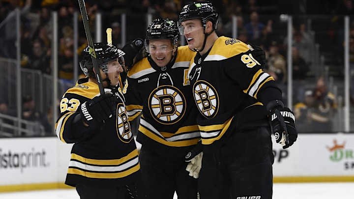 Feb 8, 2025; Boston, Massachusetts, USA; Boston Bruins defenseman Nikita Zadorov (91) (right) is congratulated by left wing Brad Marchand (63) and defenseman Charlie McAvoy (73) after scoring against the Vegas Golden Knights during the first period at TD Garden. Mandatory Credit: Winslow Townson-Imagn Images