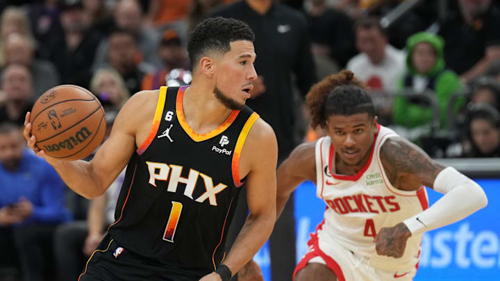 Oct 30, 2022; Phoenix, Arizona, USA; Phoenix Suns guard Devin Booker (1) dribbles against Houston Rockets guard Jalen Green (4) during the second half at Footprint Center. Mandatory Credit: Joe Camporeale-Imagn Images