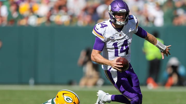 Minnesota Vikings quarterback Sam Darnold (14) escapes from Green Bay Packers defensive end Kingsley Enagbare (55) on Sunday, September 29, 2024, at Lambeau Field in Green Bay, Wis. The Vikings won the game, 31-29.
