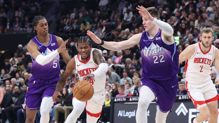Feb 22, 2025; Salt Lake City, Utah, USA; Houston Rockets guard Jalen Green (4) drives between Utah Jazz forward Cody Williams (5) and forward Kyle Filipowski (22) during the second half at Delta Center. Mandatory Credit: Rob Gray-Imagn Images