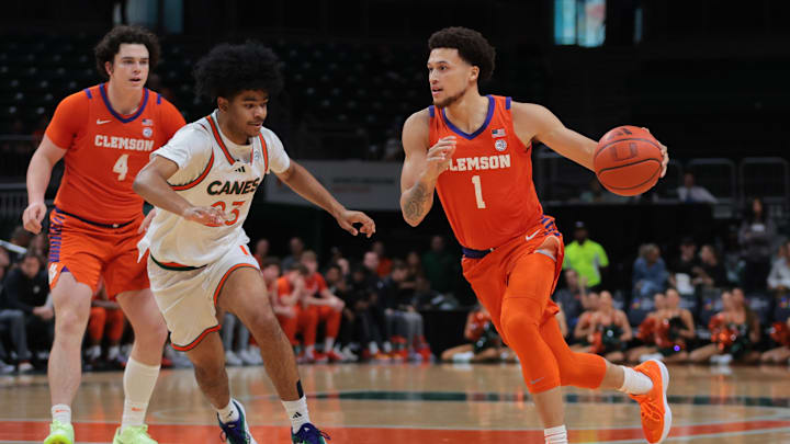 Dec 7, 2024; Coral Gables, Florida, USA; Clemson Tigers guard Chase Hunter (1) drives to the basket against Miami Hurricanes guard Austin Swartz (23) during the first half at Watsco Center. Dec 7, 2024; Coral Gables, Florida, USA; Clemson Tigers guard Chase Hunter (1) drives to the basket against Miami Hurricanes guard Austin Swartz (23) during the first half at Watsco Center.