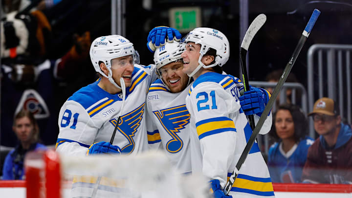 Apr 5, 2026; Denver, Colorado, USA; St. Louis Blues center Robert Thomas (18) celebrates his third goal of the game with left wing Dylan Holloway (81) and right wing Jimmy Snuggerud (21) in the third period against the Colorado Avalanche at Ball Arena. Mandatory Credit: Isaiah J. Downing-Imagn Images