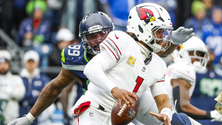 Nov 24, 2024; Seattle, Washington, USA; Arizona Cardinals quarterback Kyler Murray (1) escapes a sack attempt by Seattle Seahawks defensive end Leonard Williams (99) during the second quarter at Lumen Field. Mandatory Credit: Joe Nicholson-Imagn Images