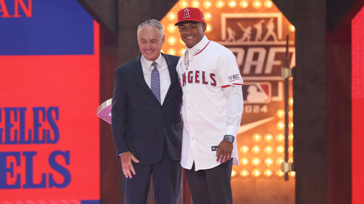 Jul 14, 2024; Ft. Worth, TX, USA;  Christian Moore is congratulated by MLB commissioner Rob Manfred after being selected by the Los Angeles Angels as the eight player taken during the first round of the MLB Draft at Cowtown Coliseum. Mandatory Credit: Kevin Jairaj-Imagn Images