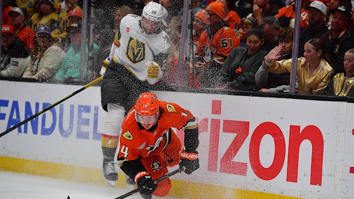 May 8, 2026; Anaheim, California, USA; Vegas Golden Knights right wing Cole Smith (22) hits Anaheim Ducks defenseman Drew Helleson (14) while playing for the puck during the third period in game three of the second round of the 2026 Stanley Cup Playoffs at Honda Center. Mandatory Credit: Gary A. Vasquez-Imagn Images