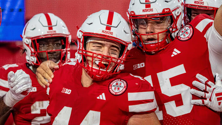 Running back Emmett Johnson, tight end Luke Lindenmeyer and quarterback Dylan Raiola celebrate after a touchdown against the Akron Zips.