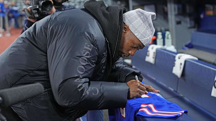 Buffalo Bills WR Joshua Palmer signs a jersey during batting practice before a game between the Baltimore Orioles and the Toronto Blue Jays.