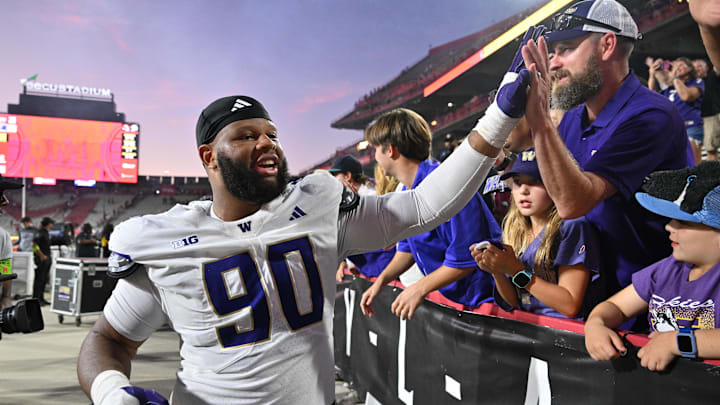 Elinneus Davis (90) celebrates with Husky fans following the UW's 24-20 comeback victory over Maryland. Elinneus Davis (90) celebrates with Husky fans following the UW's 24-20 comeback victory over Maryland.