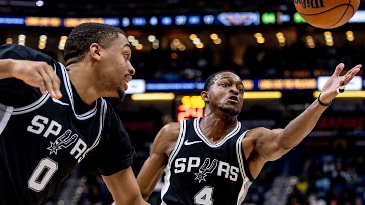 Feb 25, 2025; New Orleans, Louisiana, USA; San Antonio Spurs guard De'Aaron Fox (4) and forward Keldon Johnson (0) chase a loose ball against the New Orleans Pelicans during the second half at Smoothie King Center.