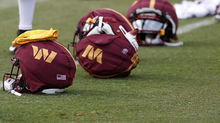 Jul 26, 2024; Ashburn, VA, USA; Washington Commanders players' helmets rest on the field on day three of training camp at Commanders Park. Mandatory Credit: Geoff Burke-Imagn Images