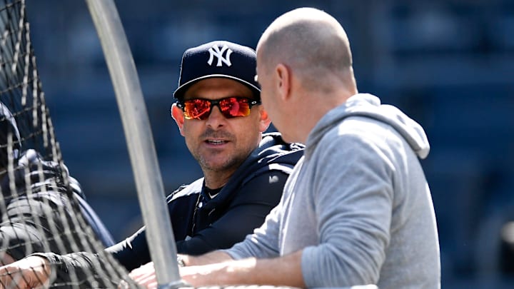 Aaron Boone and Brian Cashman chat prior to a game at Yankee Stadium.