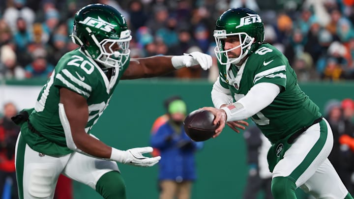 Jan 5, 2025; East Rutherford, New Jersey, USA; New York Jets quarterback Aaron Rodgers (8) hands the ball to New York Jets running back Breece Hall (20) during the first quarter of their game against the Miami Dolphins  at MetLife Stadium. Mandatory Credit: Ed Mulholland-Imagn Images