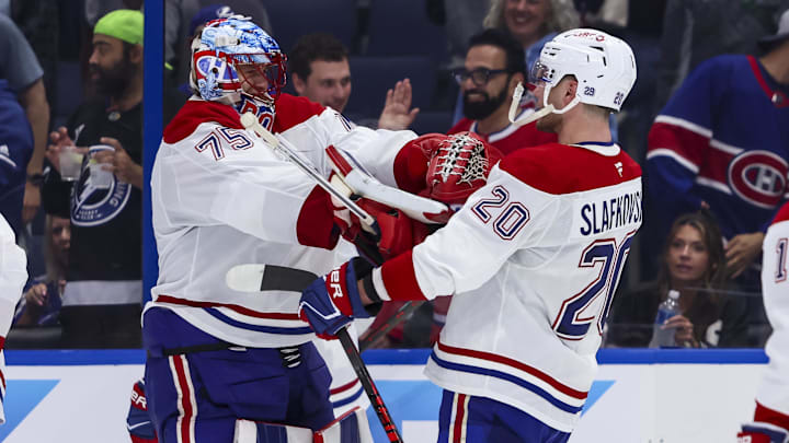 Apr 19, 2026; Tampa, Florida, USA; Montreal Canadiens forward Juraj Slafkovsky (20) celebrates the win with goalie Jakub Dobes (75) against the Tampa Bay Lightning during extra time in game one of the first round of the 2026 Stanley Cup Playoffs at Benchmark International Arena. Mandatory Credit: Morgan Tencza-Imagn Images