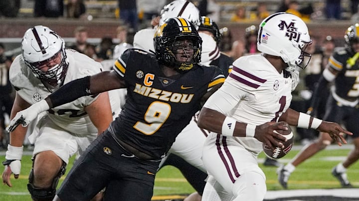 Nov 15, 2025; Columbia, Missouri, USA; Mississippi State Bulldogs quarterback Kamario Taylor (1) runs the ball as Missouri Tigers defensive end Zion Young (9) attempts the sack during the second half of the game at Faurot Field at Memorial Stadium. Mandatory Credit: Denny Medley-Imagn Images