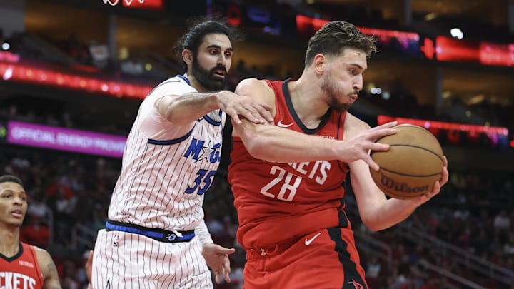 Nov 16, 2025; Houston, Texas, USA; Houston Rockets center Alperen Sengun (28) grabs a rebound away from Orlando Magic center Goga Bitadze (35) at Toyota Center. Mandatory Credit: Troy Taormina-Imagn Images
