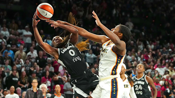 Sep 30, 2025; Las Vegas, Nevada, USA; Las Vegas Aces guard Jackie Young (0) is fouled by Indiana Fever forward Aliyah Boston (7) during the fourth quarter of game five of the second round for the 2025 WNBA Playoffs at Michelob Ultra Arena. Mandatory Credit: Stephen R. Sylvanie-Imagn Images