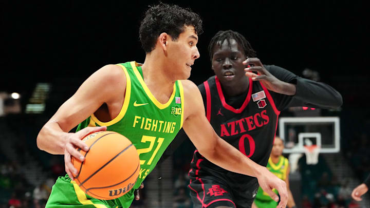 Nov 27, 2024; Las Vegas, Nevada, USA; Oregon Ducks forward Brandon Angel (21) dribbles against San Diego State Aztecs forward Magoon Gwath (0) during the first half at MGM Grand Garden Arena. Mandatory Credit: Stephen R. Sylvanie-Imagn Images