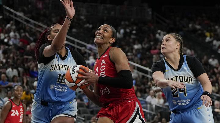 Sep 7, 2025; Las Vegas, Nevada, USA; Las Vegas Aces center A'ja Wilson (22) drives the ball between Chicago Sky center Kamilla Cardoso (10) and guard Rachel Banham (24) during the second half of a WNBA basketball game at T-Mobile Arena. Mandatory Credit: Lucas Peltier-Imagn Images