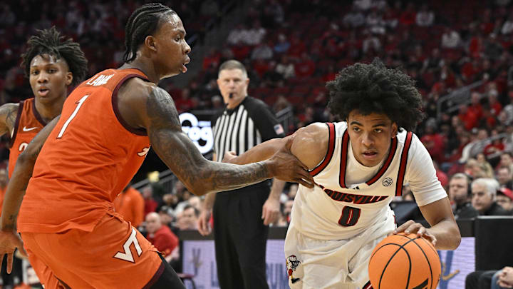 Jan 24, 2026; Louisville, Kentucky, USA;  Louisville Cardinals guard Mikel Brown Jr. (0) dribbles against Virginia Tech Hokies forward Tobi Lawal (1) during the second half at KFC Yum! Center. Mandatory Credit: Jamie Rhodes-Imagn Images
