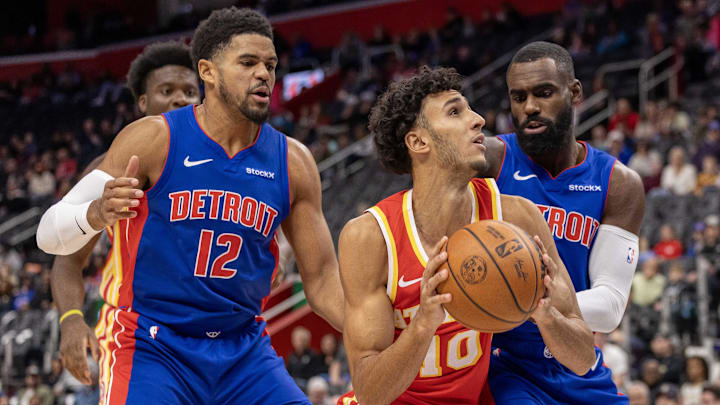 Nov 8, 2024; Detroit, Michigan, USA; Atlanta Hawks forward Zaccharie Risacher (10) battles for position with Detroit Pistons forward Tobias Harris (12) and forward Tim Hardaway Jr. (8) during the first half at Little Caesars Arena. Mandatory Credit: David Reginek-Imagn Images